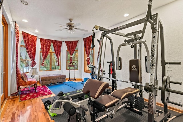 workout area with wood-type flooring, ceiling fan, and a textured ceiling