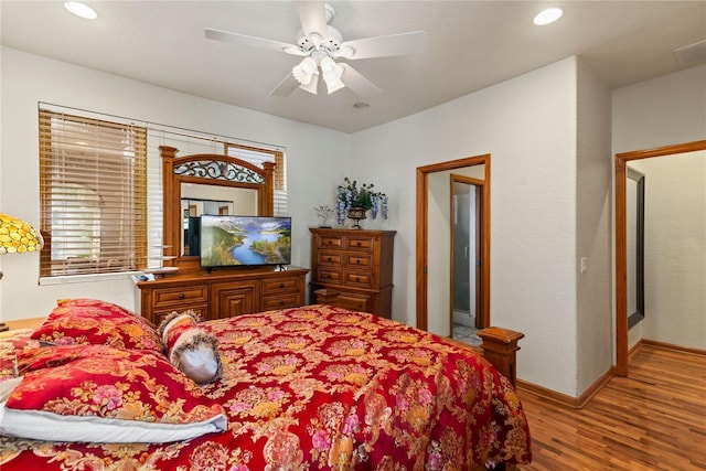 bedroom featuring multiple windows, wood-type flooring, and ceiling fan