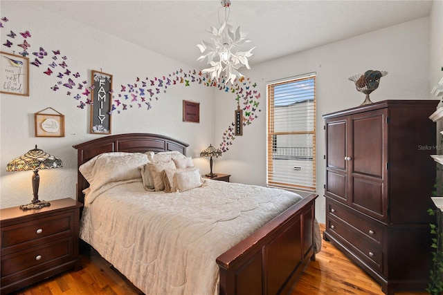 bedroom featuring a chandelier and light wood-type flooring