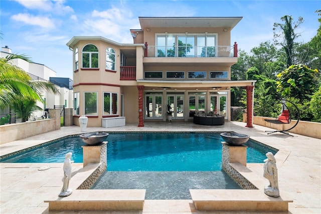 back of house featuring ceiling fan, a patio area, and a balcony