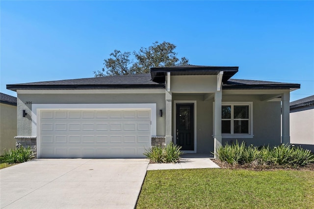 prairie-style home with a garage and a front lawn