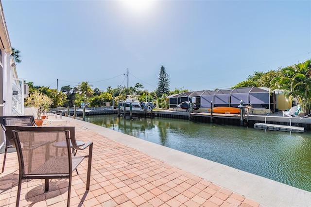 view of patio / terrace featuring a dock, glass enclosure, and a water view