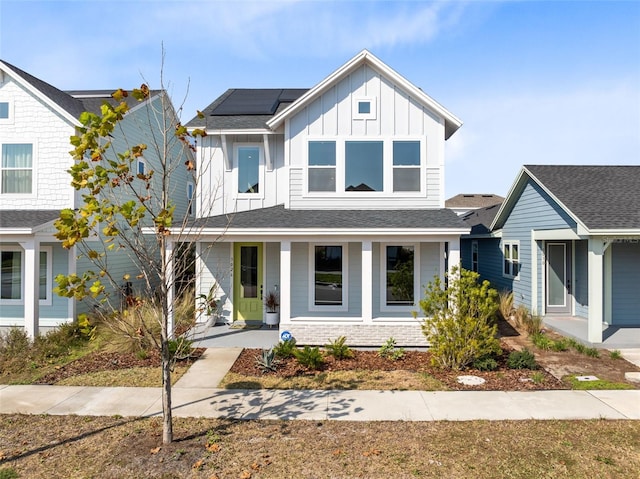 view of front of property featuring a porch and solar panels