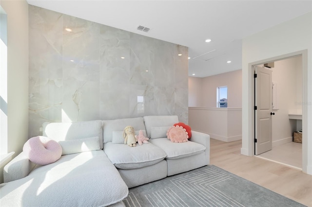 living room with tile walls and light hardwood / wood-style floors