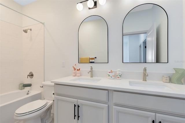 full bathroom with vanity, tiled shower / bath, and toilet