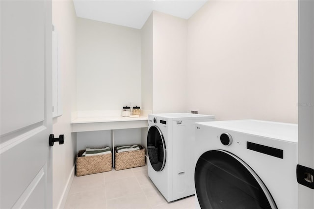 laundry room featuring washing machine and dryer and light tile patterned floors