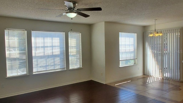 unfurnished room featuring dark hardwood / wood-style floors, ceiling fan with notable chandelier, and a textured ceiling