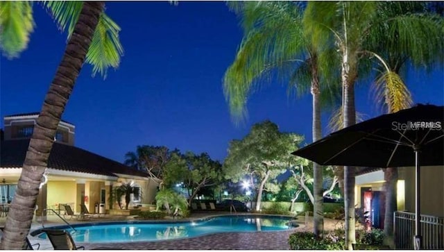 view of pool at twilight