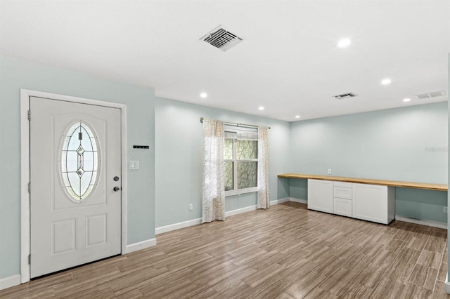 entryway with light hardwood / wood-style flooring and built in desk