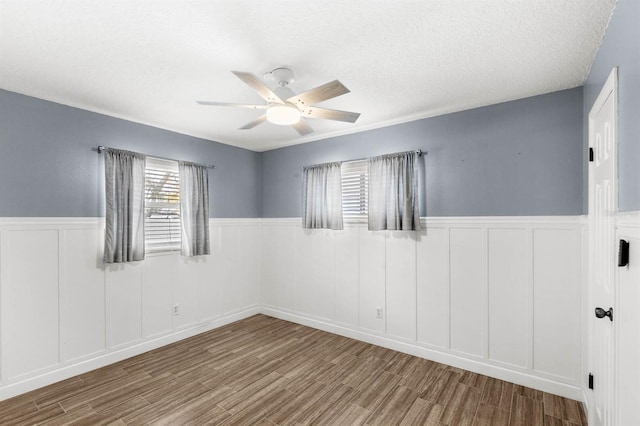 spare room featuring a textured ceiling, light hardwood / wood-style floors, and ceiling fan