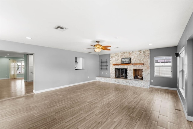 unfurnished living room featuring a healthy amount of sunlight, a fireplace, and light hardwood / wood-style floors