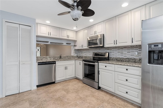 kitchen with ceiling fan, white cabinetry, backsplash, stainless steel appliances, and light stone countertops