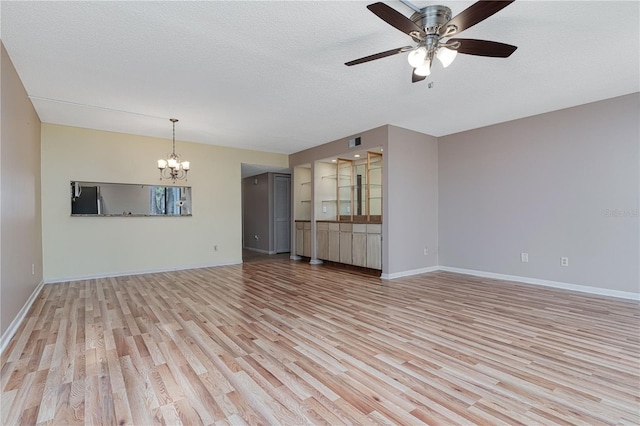 unfurnished living room featuring ceiling fan with notable chandelier, a textured ceiling, and light hardwood / wood-style floors