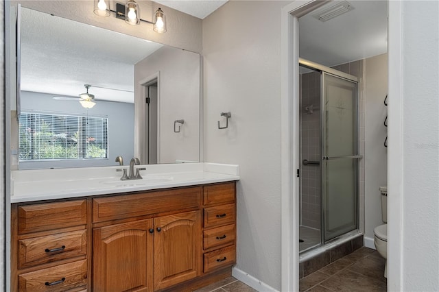 bathroom with walk in shower, ceiling fan, vanity, and toilet