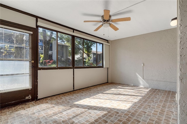 unfurnished sunroom featuring ceiling fan