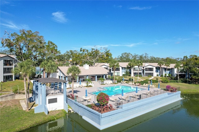 view of pool featuring a lawn, a patio, and a water view