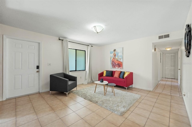 living room with a textured ceiling and light tile patterned flooring