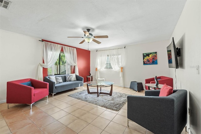 tiled living room with ceiling fan and a textured ceiling