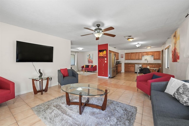 living room featuring light tile patterned flooring, ceiling fan, and sink