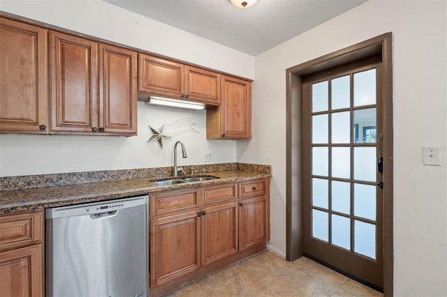 kitchen featuring sink, a textured ceiling, light tile patterned floors, dishwasher, and dark stone counters