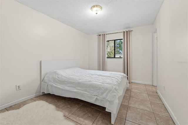 bedroom with tile patterned flooring and a textured ceiling