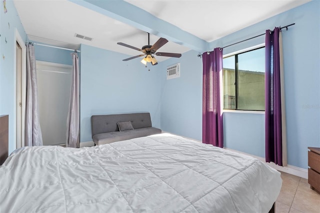 bedroom featuring ceiling fan, beam ceiling, a closet, and light tile patterned floors