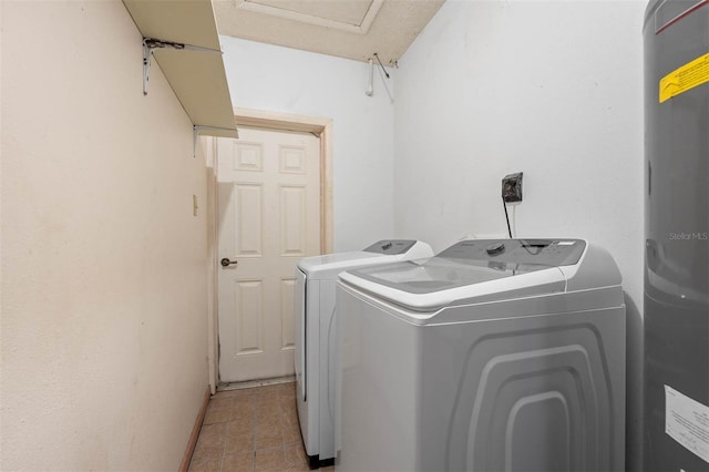 washroom featuring tile patterned flooring, water heater, and washing machine and clothes dryer