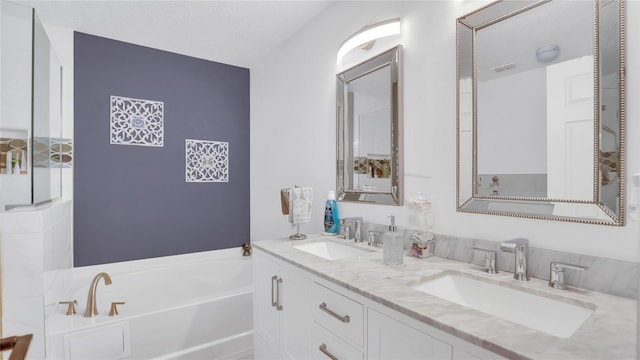 bathroom with vanity, a textured ceiling, and a washtub