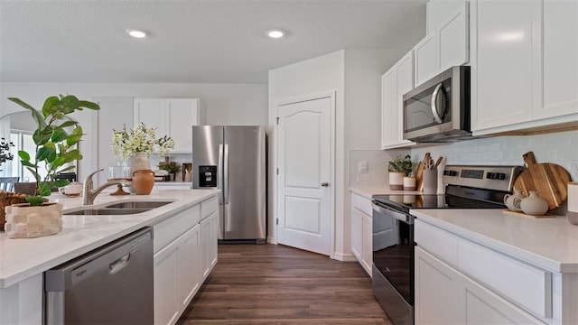 kitchen with appliances with stainless steel finishes, sink, and white cabinets