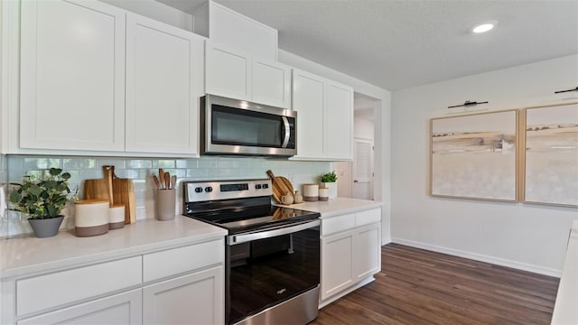 kitchen with white cabinetry, backsplash, dark wood-type flooring, and stainless steel appliances