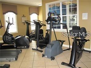 exercise room featuring tile patterned floors and a healthy amount of sunlight