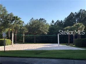 view of property's community with a lawn and volleyball court