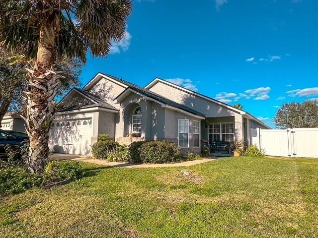 ranch-style home with a garage and a front lawn