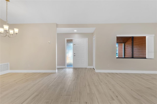 entrance foyer featuring a notable chandelier and light hardwood / wood-style flooring