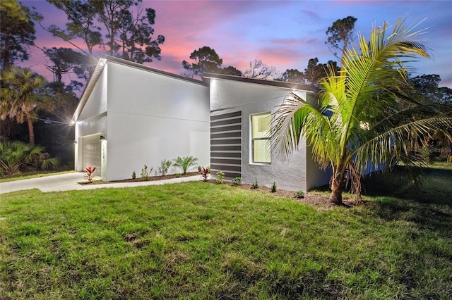 view of front of house featuring a garage and a lawn