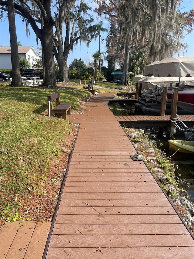 view of dock featuring a water view and a lawn