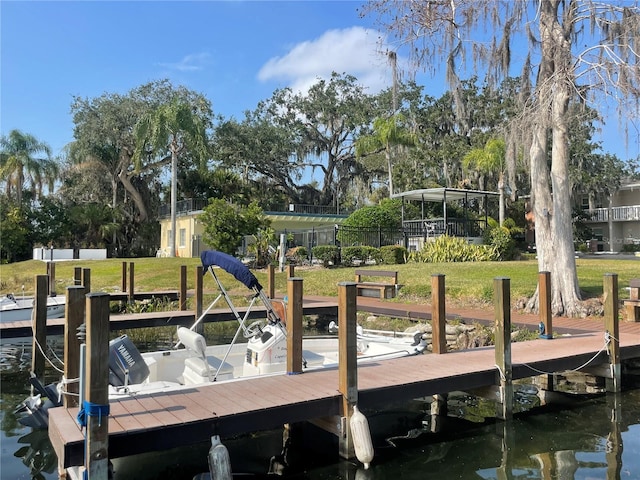 view of dock with a water view and a yard