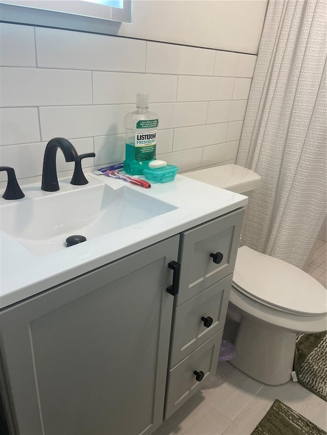 bathroom with toilet, tile walls, vanity, tile patterned flooring, and decorative backsplash