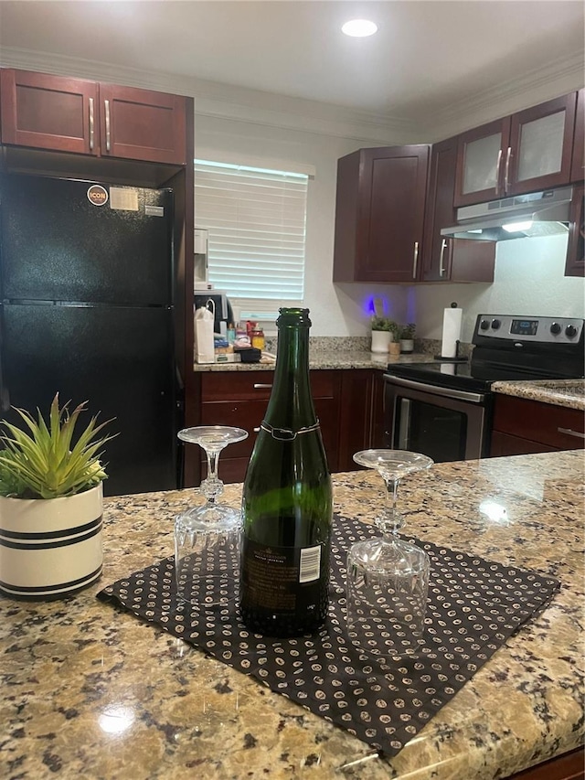 kitchen featuring light stone countertops, black fridge, ornamental molding, and stainless steel range with electric stovetop