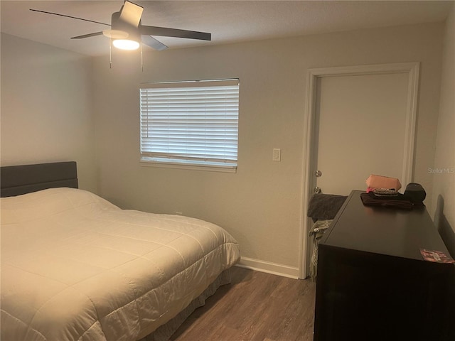 bedroom with dark hardwood / wood-style floors and ceiling fan