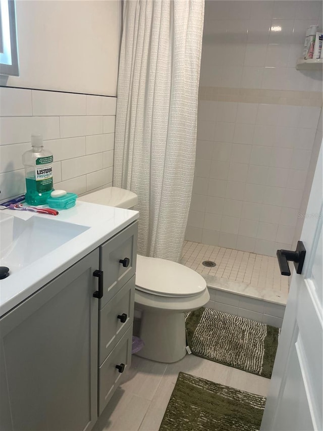 bathroom featuring tile walls, tile patterned flooring, vanity, toilet, and a shower with shower curtain