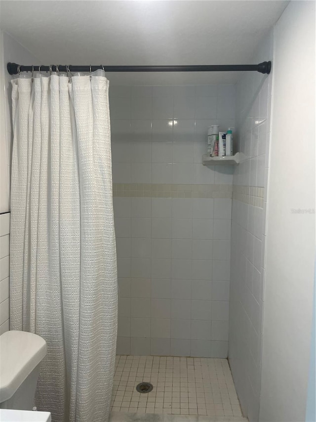 bathroom with curtained shower and toilet