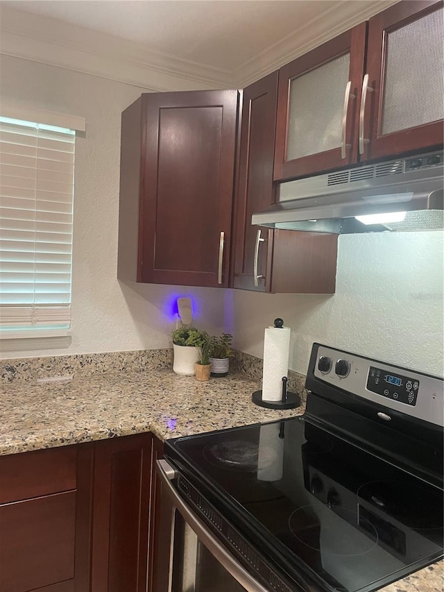 kitchen featuring stainless steel range with electric stovetop, light stone counters, and ornamental molding