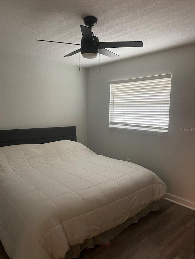 bedroom with hardwood / wood-style floors, a textured ceiling, and ceiling fan