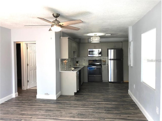 kitchen featuring stainless steel appliances, sink, dark hardwood / wood-style flooring, and gray cabinets