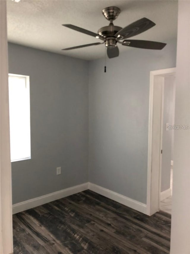 spare room featuring ceiling fan and dark hardwood / wood-style floors