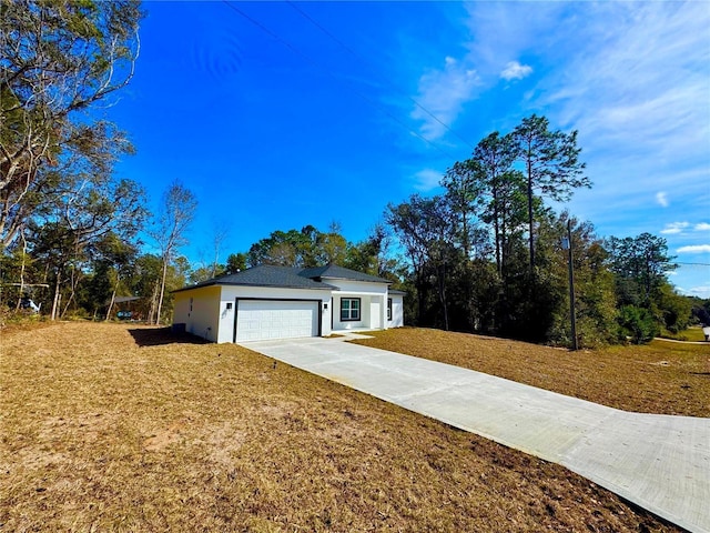 single story home featuring a garage and a front lawn