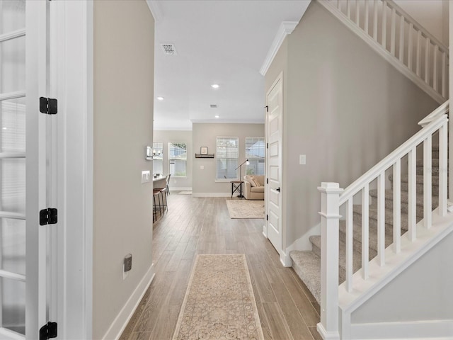 entrance foyer featuring hardwood / wood-style flooring and ornamental molding