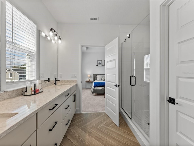 bathroom featuring parquet flooring, vanity, and a shower with shower door