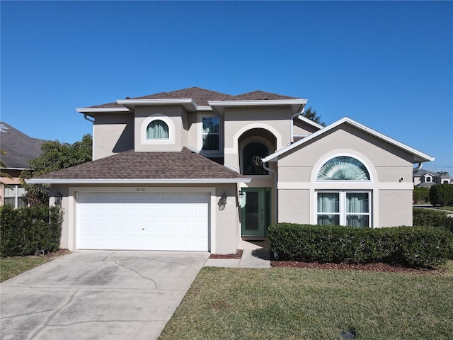 view of front of property featuring driveway, a shingled roof, a front yard, and stucco siding